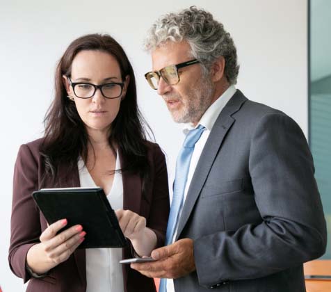 Secretary talking with an Executive regarding a document and action item in Convene