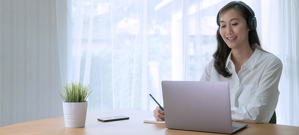 woman watching virtual annual shareholders meeting with laptop